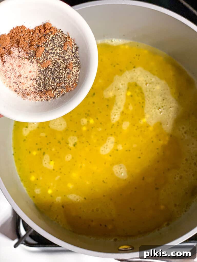 Harvest Roasted Pumpkin Couscous Salad 6 A medium saucepan on the stove with a tablespoon of olive oil and uncooked couscous, ready for toasting with spices.