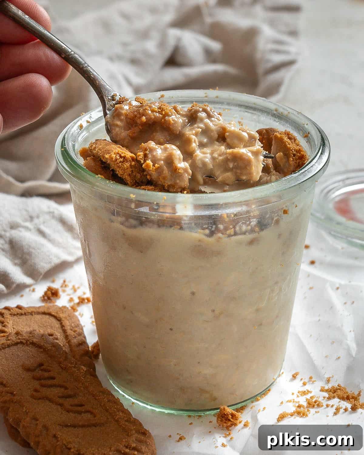 Dreamy Biscoff Overnight Oats 2 A glass jar filled with creamy Biscoff Overnight Oats, topped with crushed Biscoff cookies, sliced bananas, and chocolate chips, ready for breakfast.