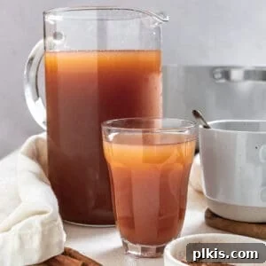 Cozy Spiced Apple Warmer 14 completed Mulled Apple Cider in two cups and a pitcher