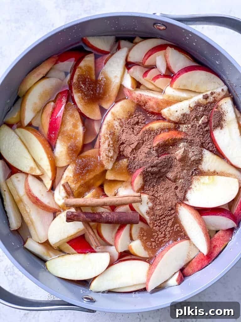 Cozy Spiced Apple Warmer 5 Spices being added to a bowl of sliced apples.