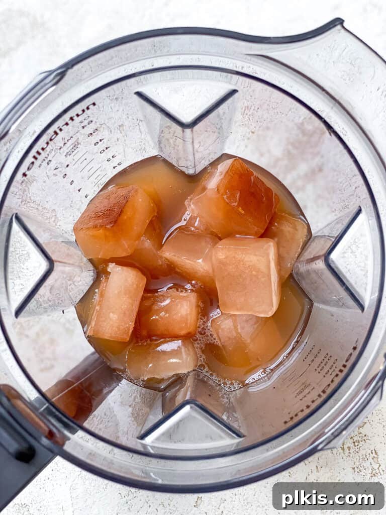 Frozen Apple Cider Delight 5 Frozen apple cider ice cubes being added to a blender, ready for the next step of making a slushie.