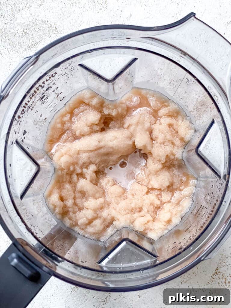 Frozen Apple Cider Delight 6 Blended apple cider slushie in a blender carafe after processing, showing a smooth and icy texture.