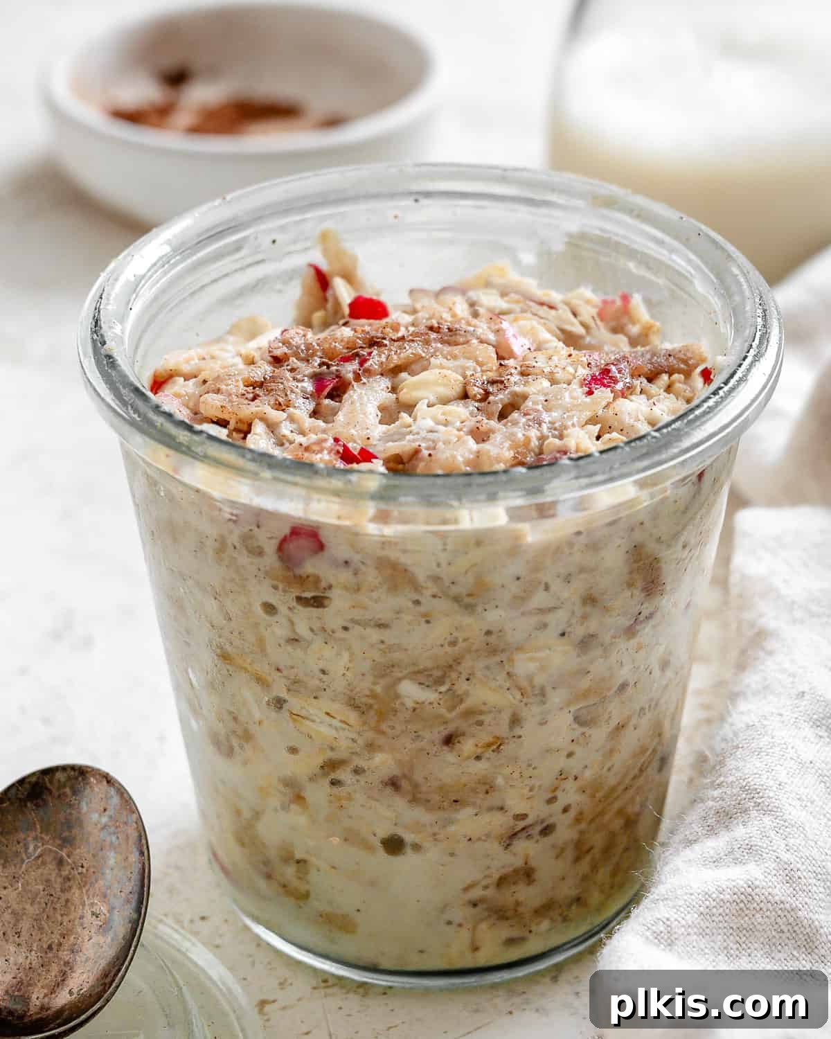 Apple Pie Overnight Oats 2 completed Apple Cinnamon Overnight Oats in a glass cup, ready to be enjoyed as a healthy breakfast.