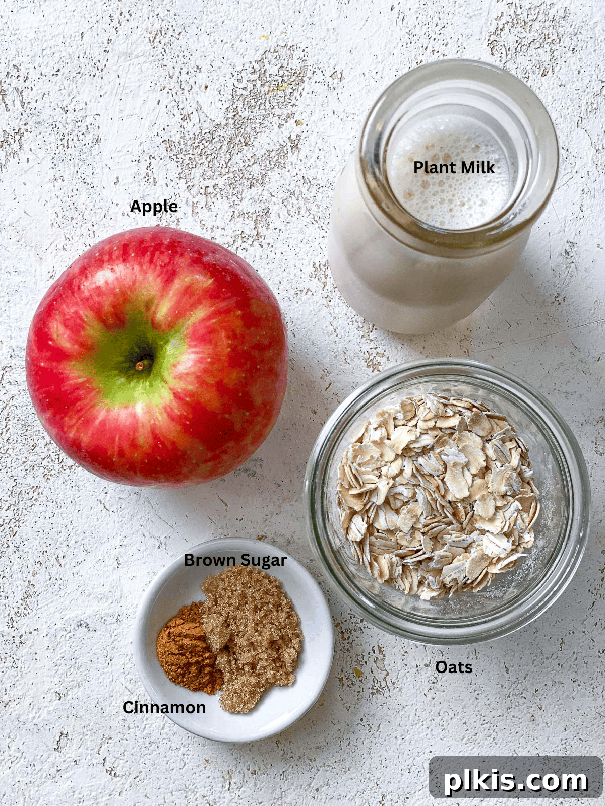 Apple Pie Overnight Oats 3 ingredients for Apple Cinnamon Overnight Oats measured out against a white surface, showcasing simplicity.