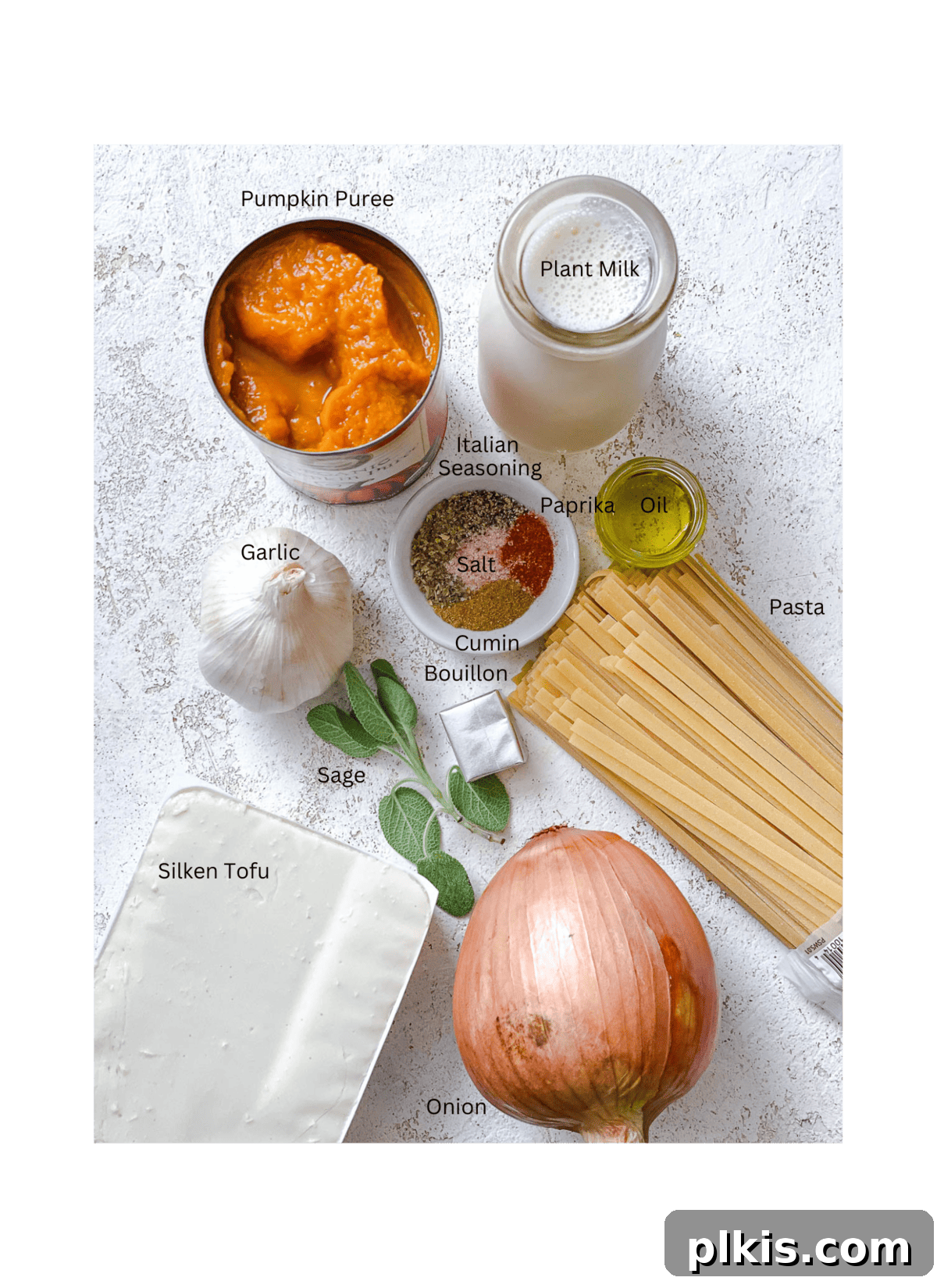 Velvety Pumpkin Pasta 3 ingredients for Creamy Pumpkin Pasta (Vegan) measured out on a white surface, including pumpkin puree, sage, onions, and spices