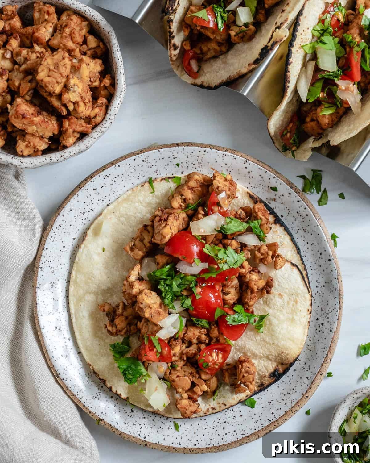 finished Chipotle Lime Street Style Tacos on a plate against a white background, garnished with cilantro and lime