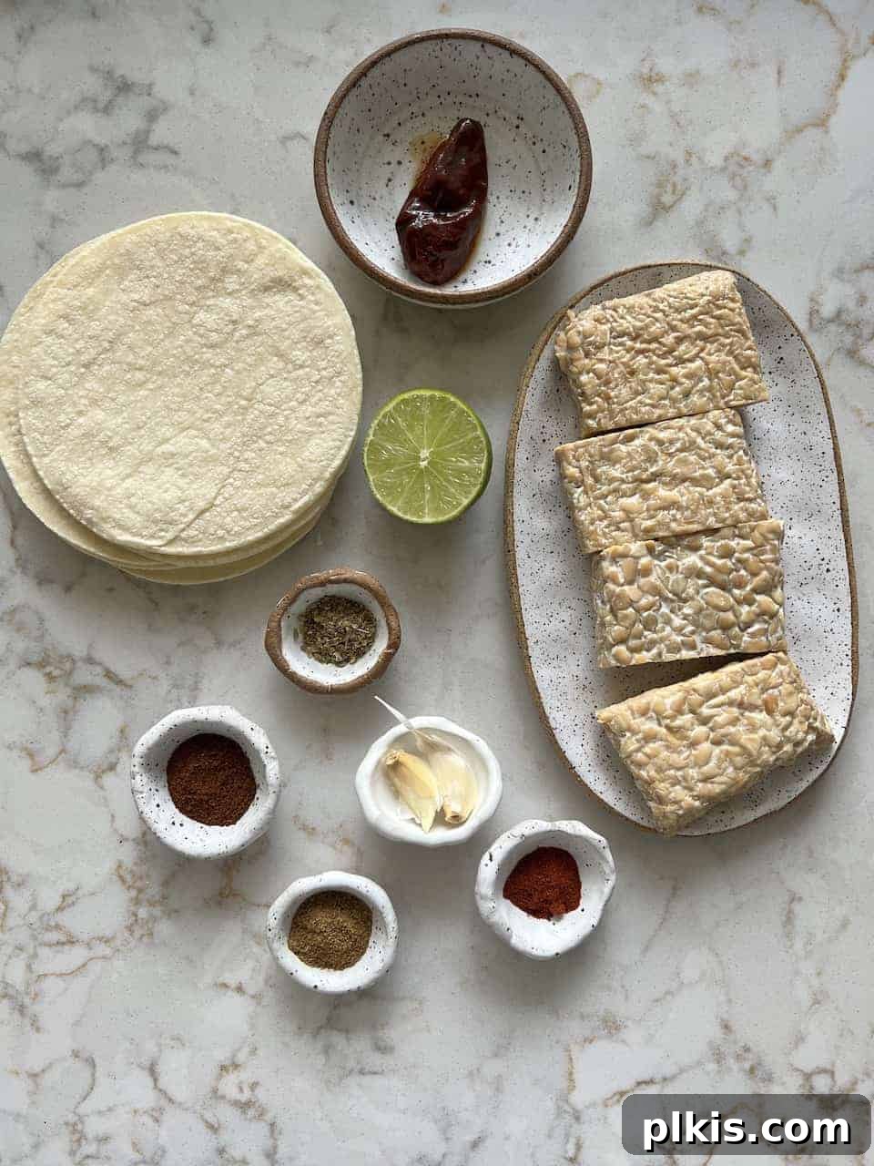 ingredients for Chipotle Lime Street Style Tacos laid out on a white background, including tempeh, chipotle, lime, and various spices