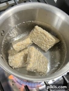 tempeh block in a bowl after being boiled