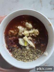 process of ingredients being mixed in a white bowl for Chipotle Lime Street Style Tacos, showing spices and liquids blending