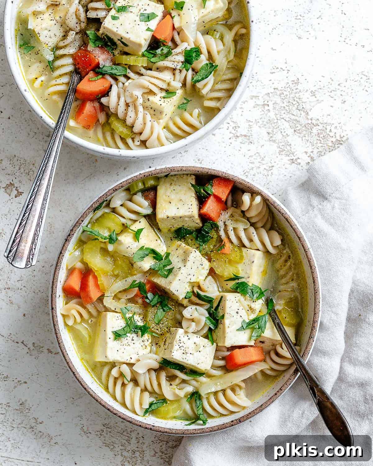 Vegan Chicken Noodle Soup: Stovetop, Instant Pot, and Slow Cooker 2 two bowls of completed cooked soup on a white surface
