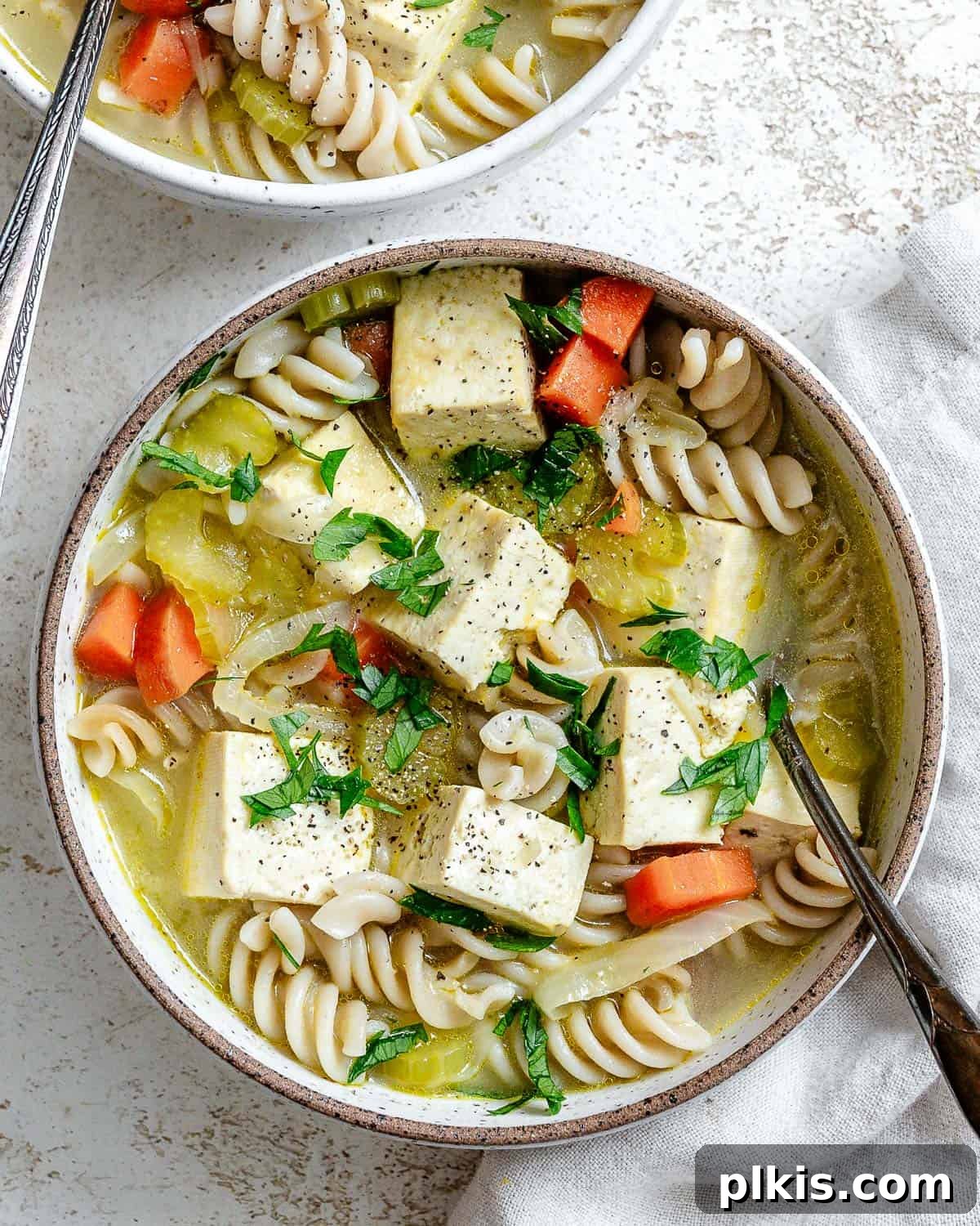 Vegan Chicken Noodle Soup: Stovetop, Instant Pot, and Slow Cooker 12 bowl of completed cooked soup on a white surface