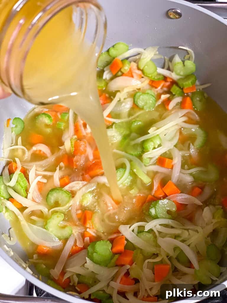 Vegan Chicken Noodle Soup: Stovetop, Instant Pot, and Slow Cooker 8 process shot of adding veggie broth
