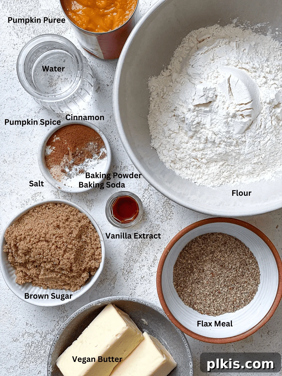 Vegan Pumpkin Delight 3 All the measured ingredients for Vegan Pumpkin Cake laid out on a white surface, ready for baking.