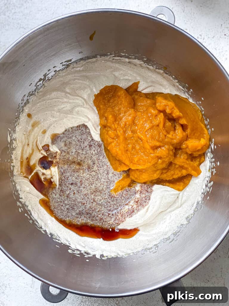 Vegan Pumpkin Delight 6 Process shot: Adding pumpkin puree, flax mixture, and vanilla extract to the creamed butter and sugar.