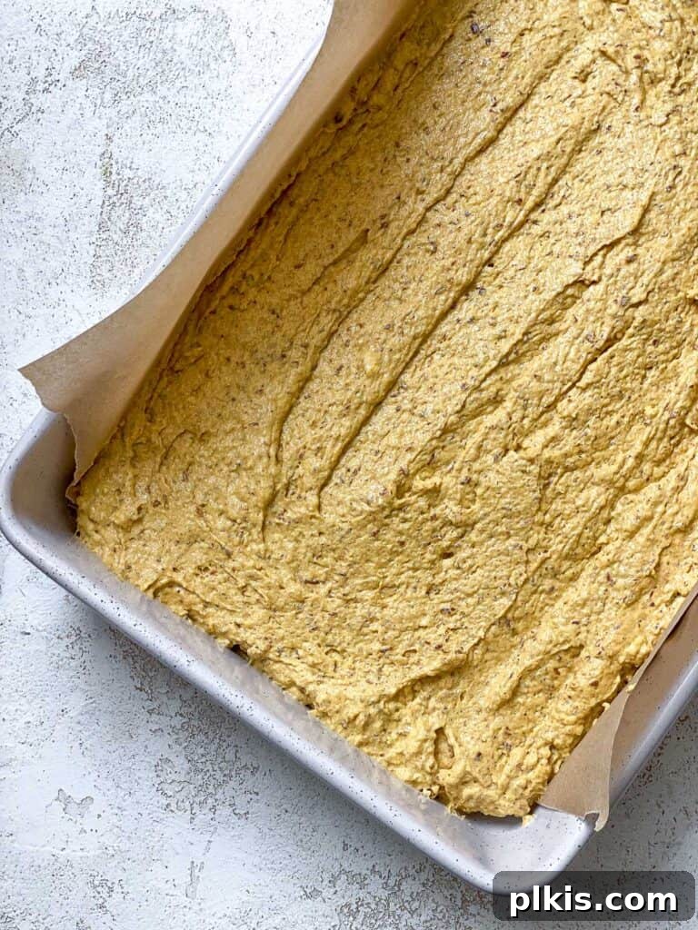 Vegan Pumpkin Delight 8 Process shot: Unbaked pumpkin cake batter evenly spread in a parchment-lined baking pan.