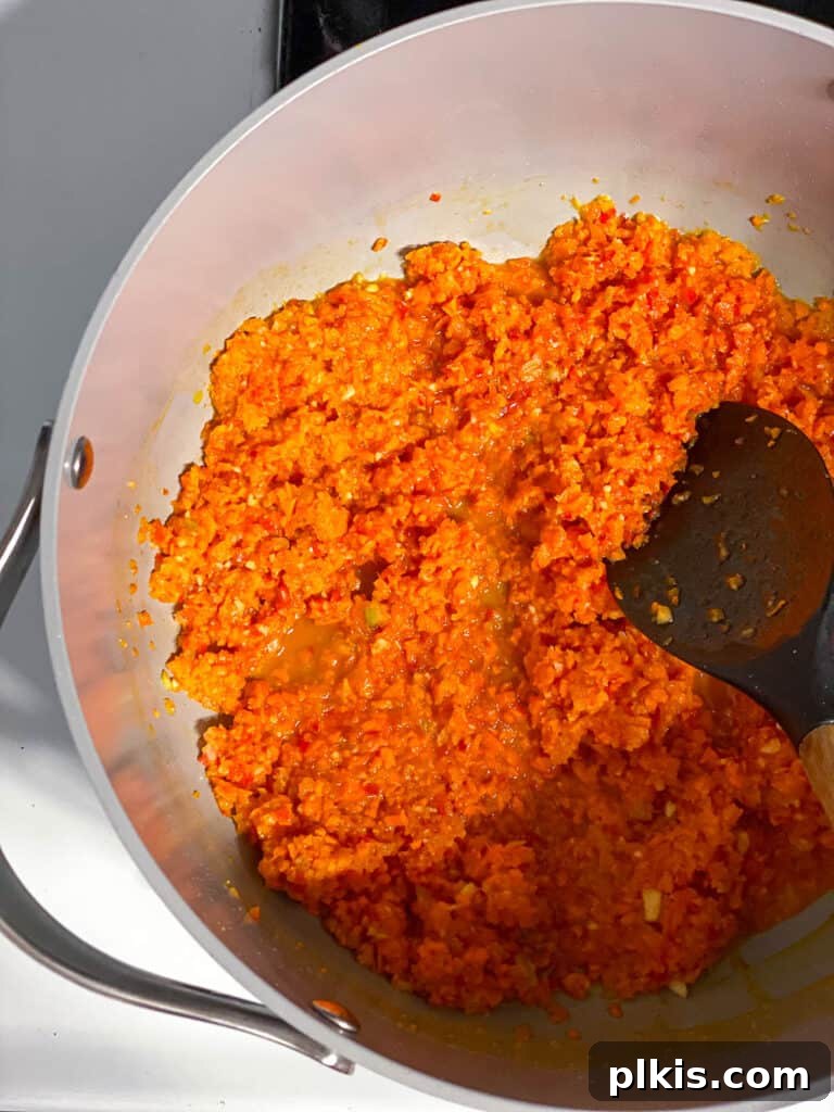 Hearty Lentil Sloppy Joes for Stove Top or Slow Cooker 9 Process shot of aromatic vegetables sautéing in a large pan on the stove.
