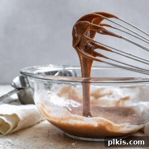 completed Pumpkin Spice Glaze in a glass bowl drizzling from a whisk