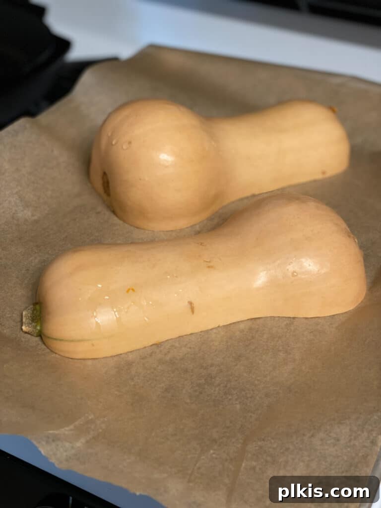 Golden Thai Squash Elixir 5 Butternut squash halves placed cut-side down on a baking sheet, ready for the oven.