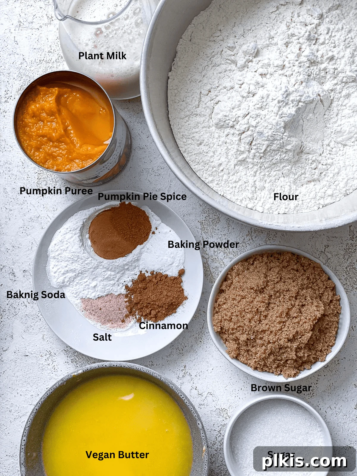 Ingredients for Easy Vegan Pumpkin Bundt Cake meticulously measured and arranged on a clean white surface, showcasing essential components for a delicious fall dessert.
