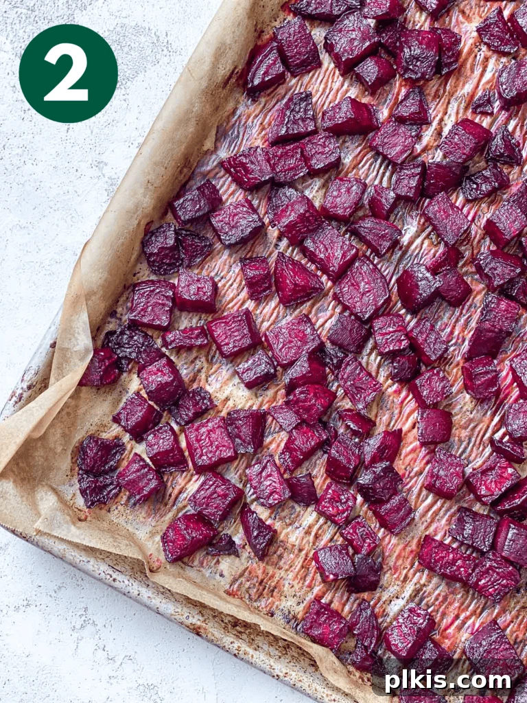 Vibrant Roasted Beet Salad with Vegan Feta and Crisp Apple 6 Roasted beets on a baking tray, showing tender texture and slightly charred edges after cooking.