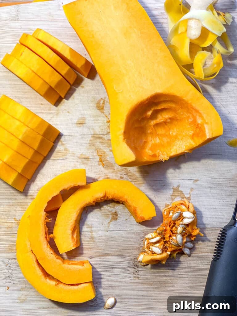 Process shot of a butternut squash being carefully cut on a cutting board, demonstrating preparation for roasting.