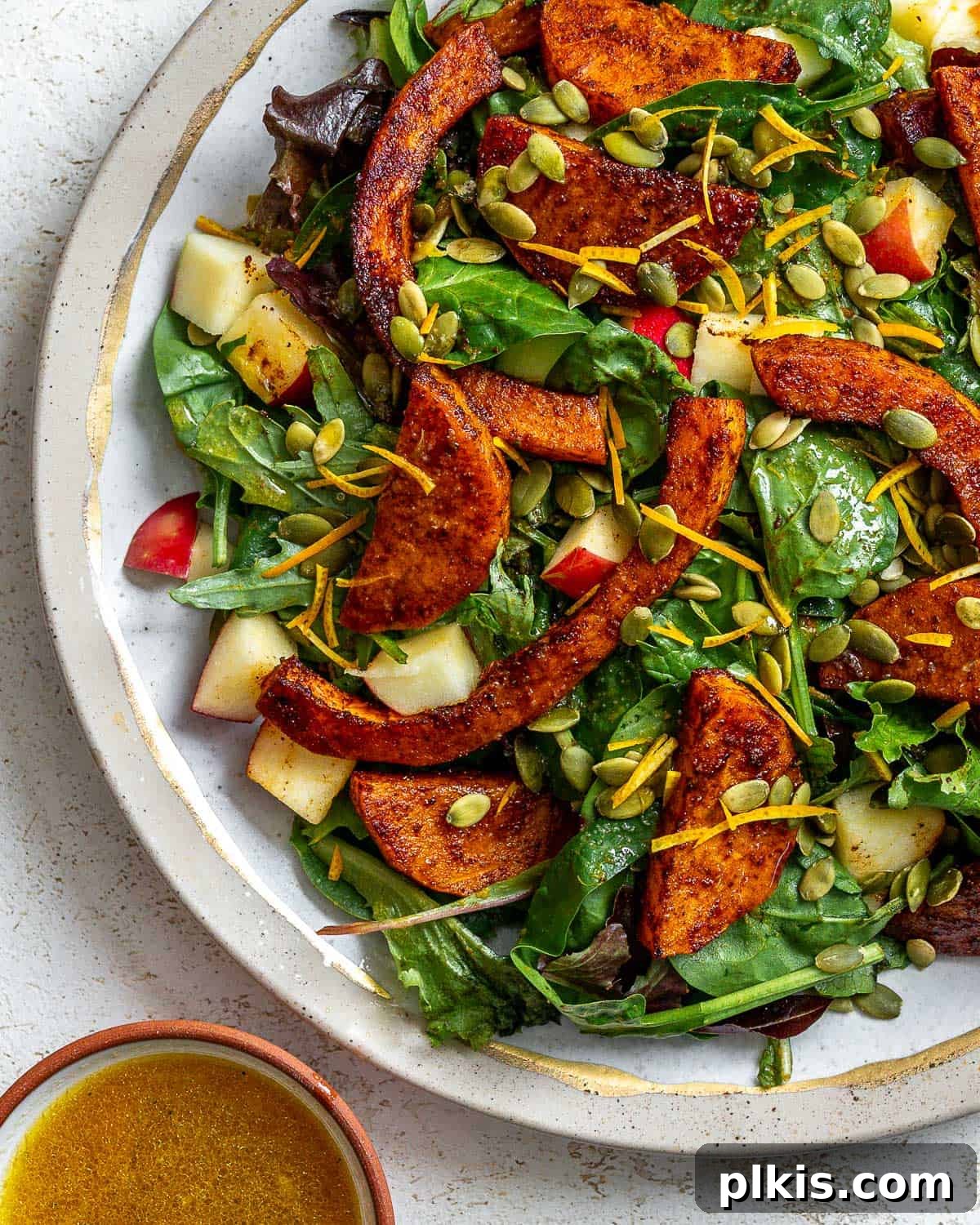 A close-up shot of the completed Easy Butternut Squash Salad on a white surface, highlighting its vibrant colors and textures.
