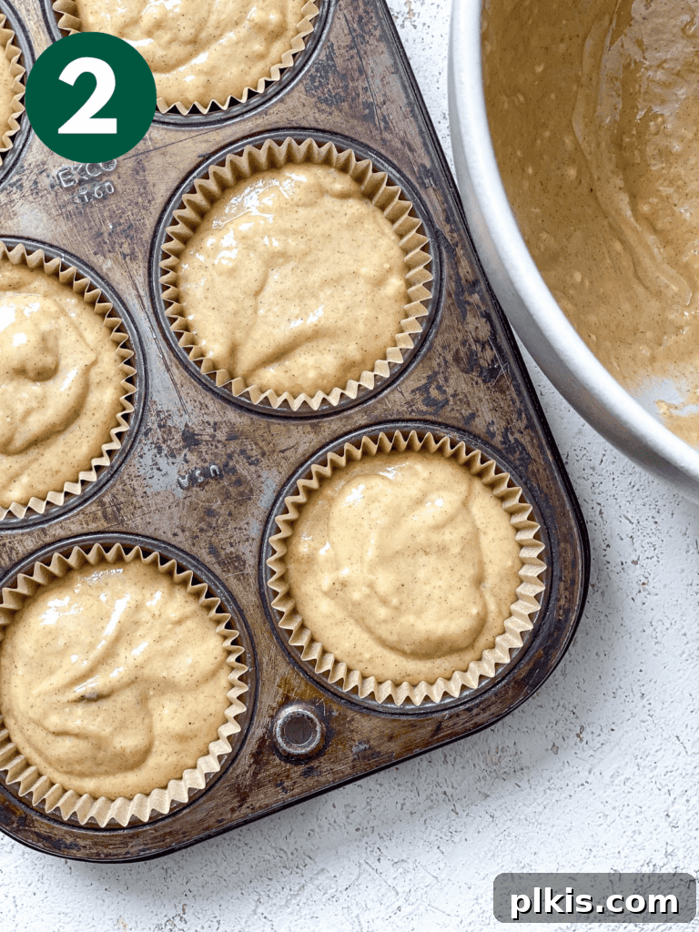 Spiced Vegan Pumpkin Bites 5 Pre-baked vegan pumpkin cupcake batter portioned into muffin liners in a baking tin, ready for the oven.