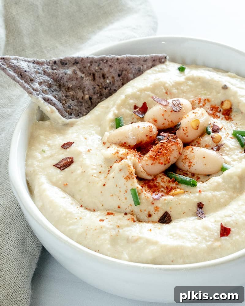 Creamy White Bean & Chive Dip 2 A beautifully presented bowl of creamy Cold White Bean Dip with fresh chives, set against a pristine white background. Perfect for appetizers and spreads.