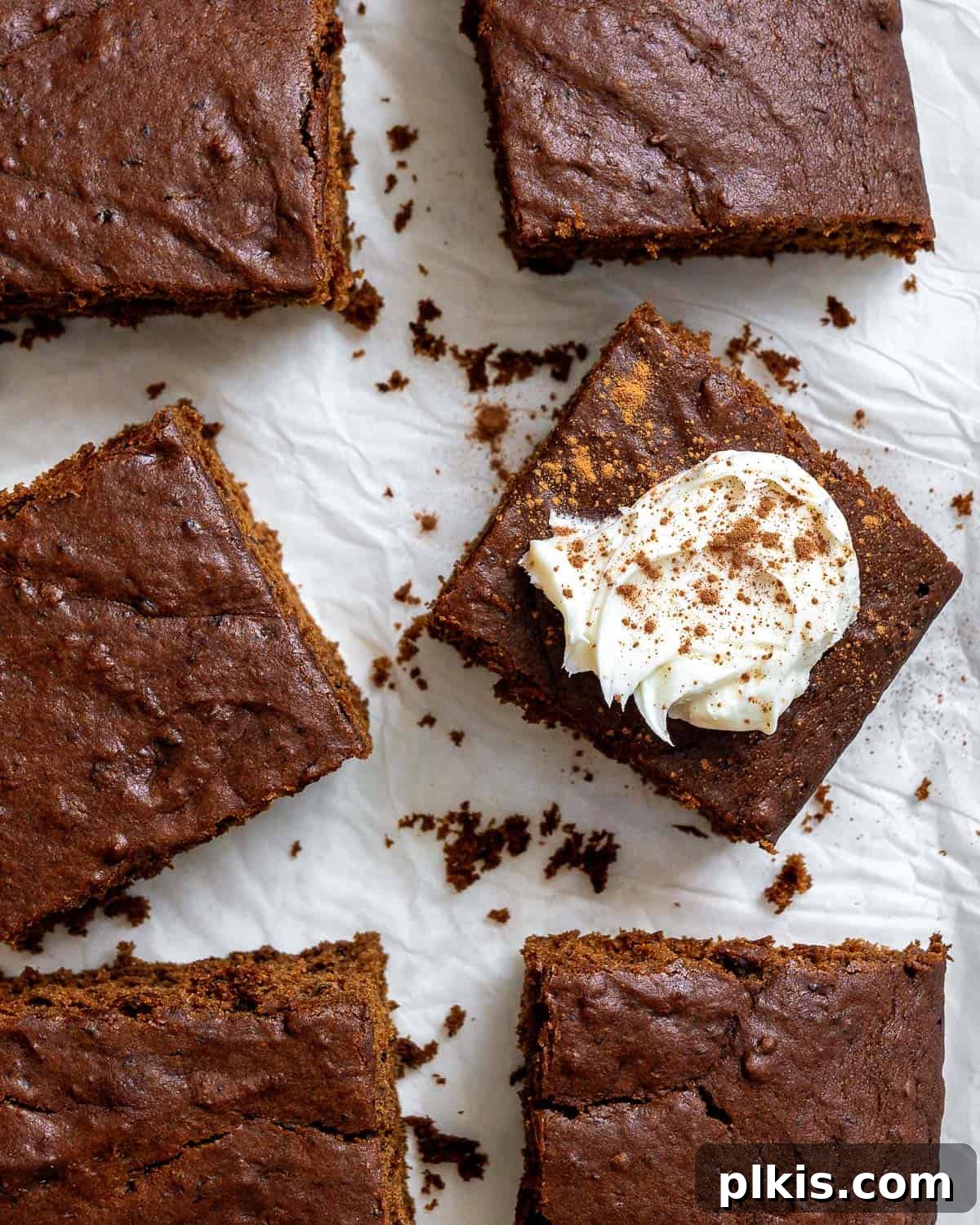 Cozy Vegan Gingerbread Spice Cake 2 Slices of fluffy, moist vegan gingerbread cake on a white surface, garnished with a light dusting of powdered sugar, perfect for holiday gatherings.
