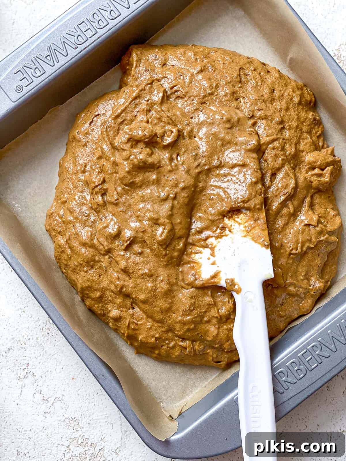 Cozy Vegan Gingerbread Spice Cake 8 A process shot of spreading the smooth vegan gingerbread cake batter evenly into a prepared baking pan.