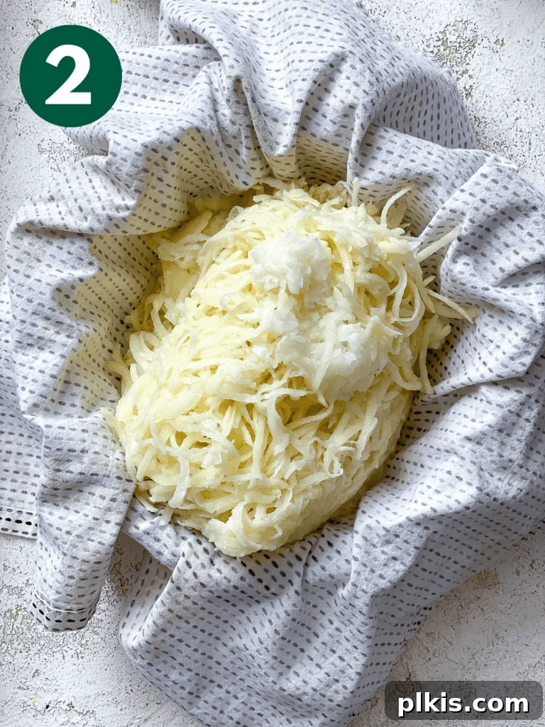 Crispy Vegan Potato Latkes 5 Process shot showing grated potatoes contained within a cheesecloth, illustrating the preparation step before squeezing out liquid.