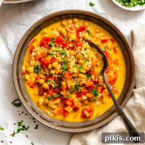 Completed Coconut Chickpea Curry Soup in pot on white surface.