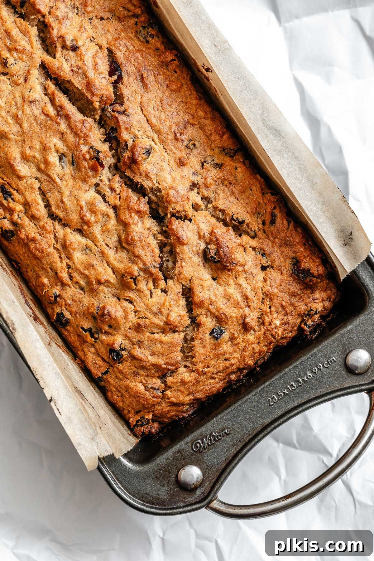 A freshly baked and cooled Vegan Fruit Cake [Fruit Loaf] sliced, revealing its moist, fruit-filled interior, ready for serving.