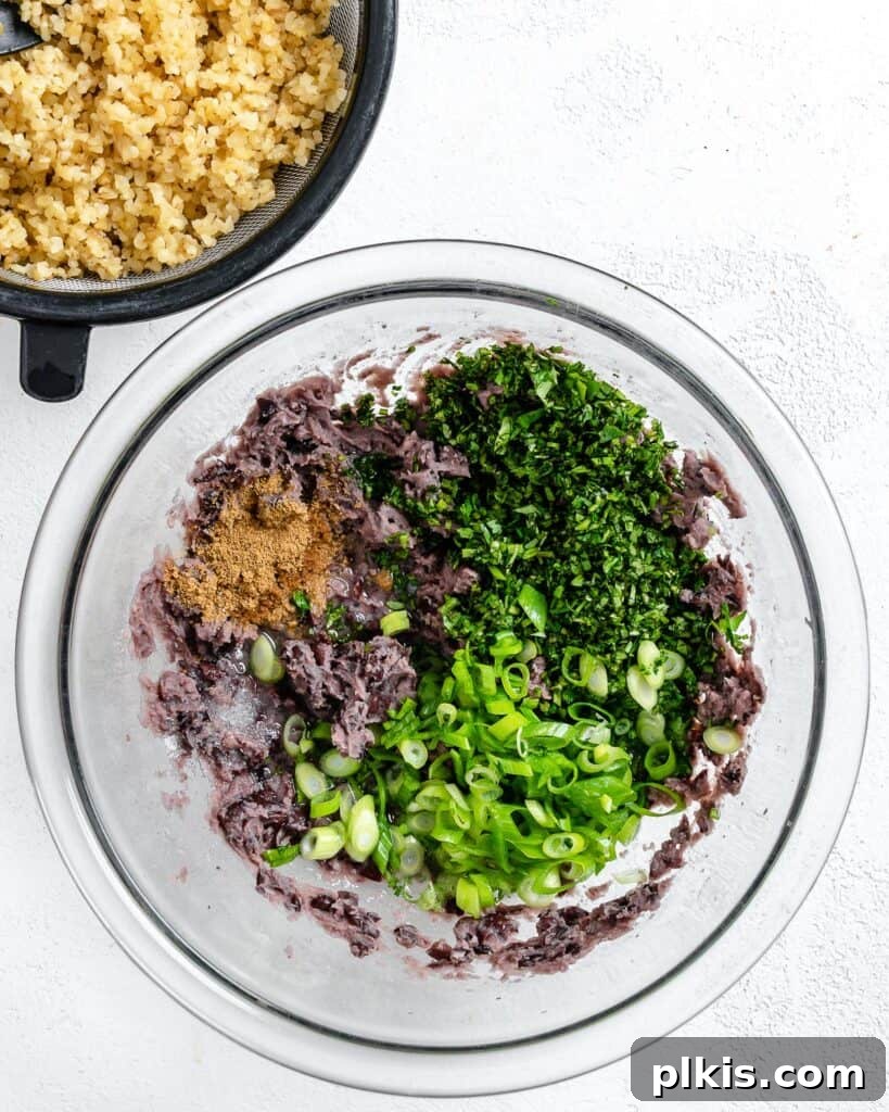 Hearty Vegan Black Bean and Bulgur Burgers 7 process shot of adding ingredients together in a glass bowl