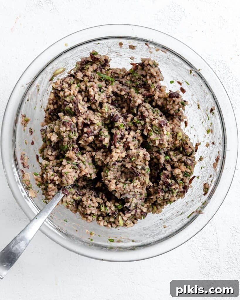 Hearty Vegan Black Bean and Bulgur Burgers 8 process shot of showing mashed ingredients together in a glass bowl