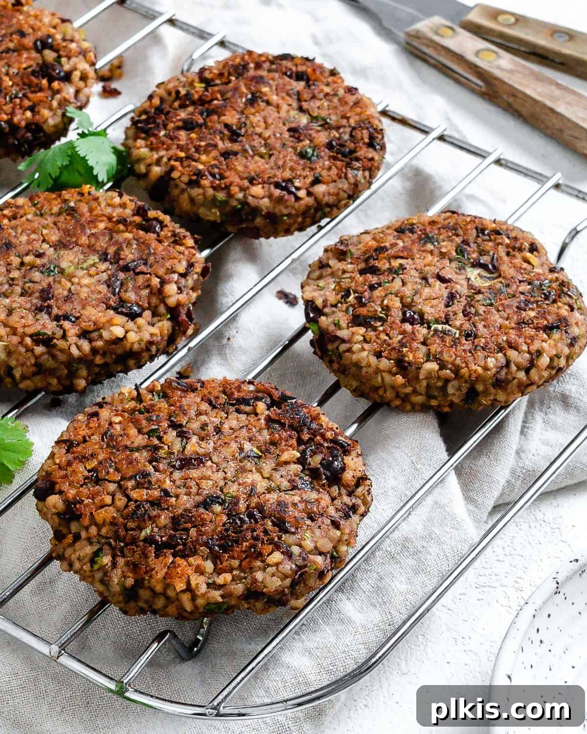 Hearty Vegan Black Bean and Bulgur Burgers 10 completed Vegan Black Bean and Bulgur Burgers on a wire rack against a light surface