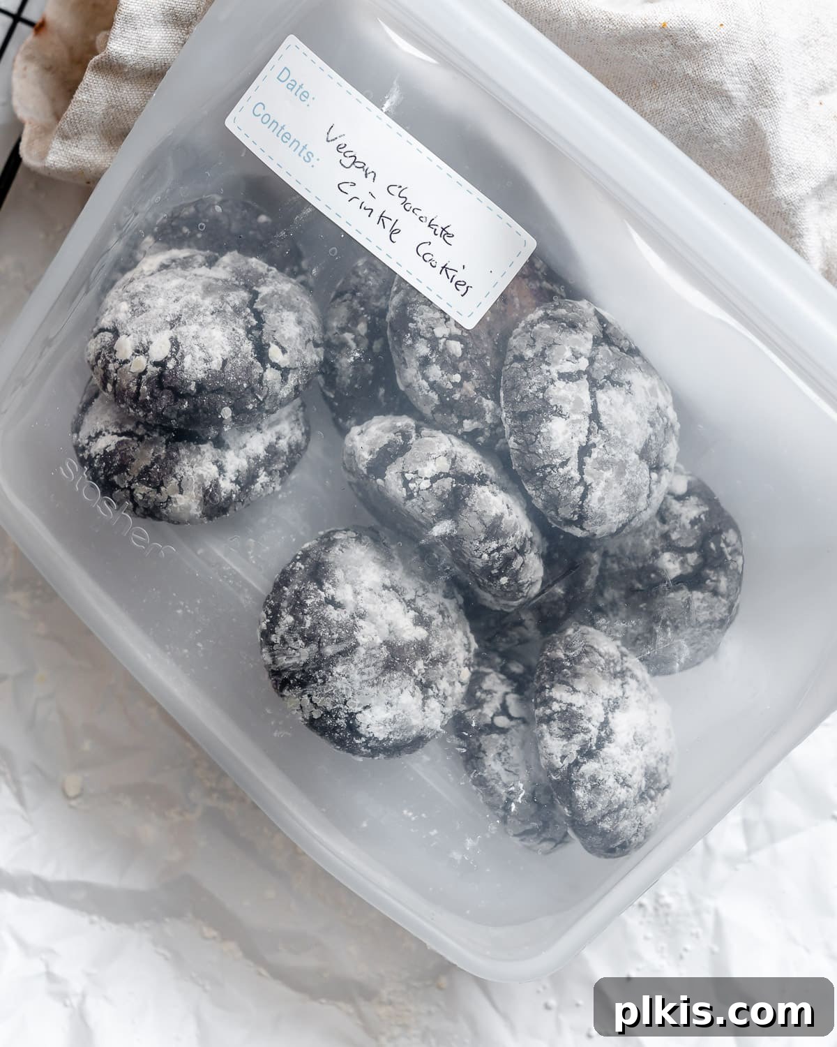 Completed Vegan Chocolate Crinkle Cookies neatly stacked inside a clear storage bag, ready for freezing or gifting.