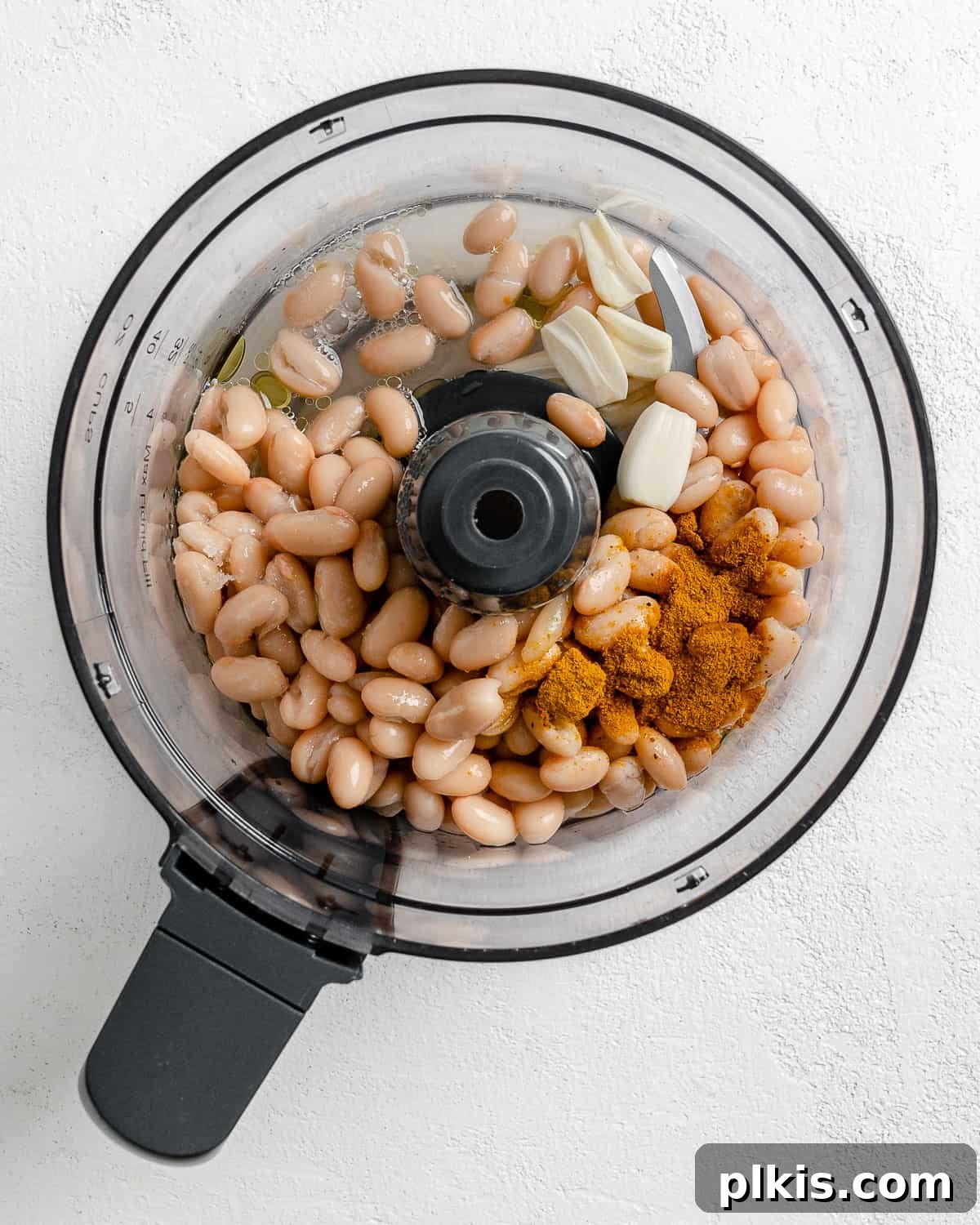 Creamy Vegan Curried White Bean Dip 5 Close-up process shot of all ingredients for curried white bean dip loaded into a food processor, ready for blending.