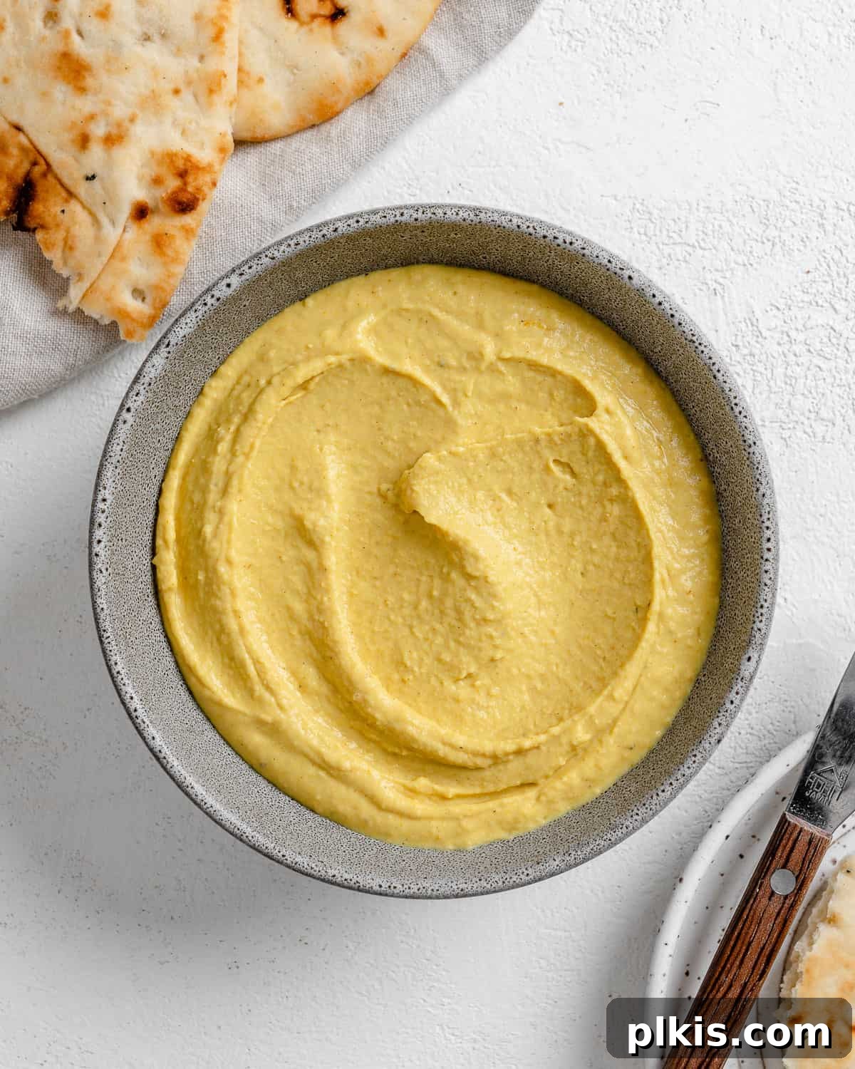 Creamy Vegan Curried White Bean Dip 7 The completed Curried White Bean Dip, beautifully plated in a grey bowl with fresh bread, ready to be served.