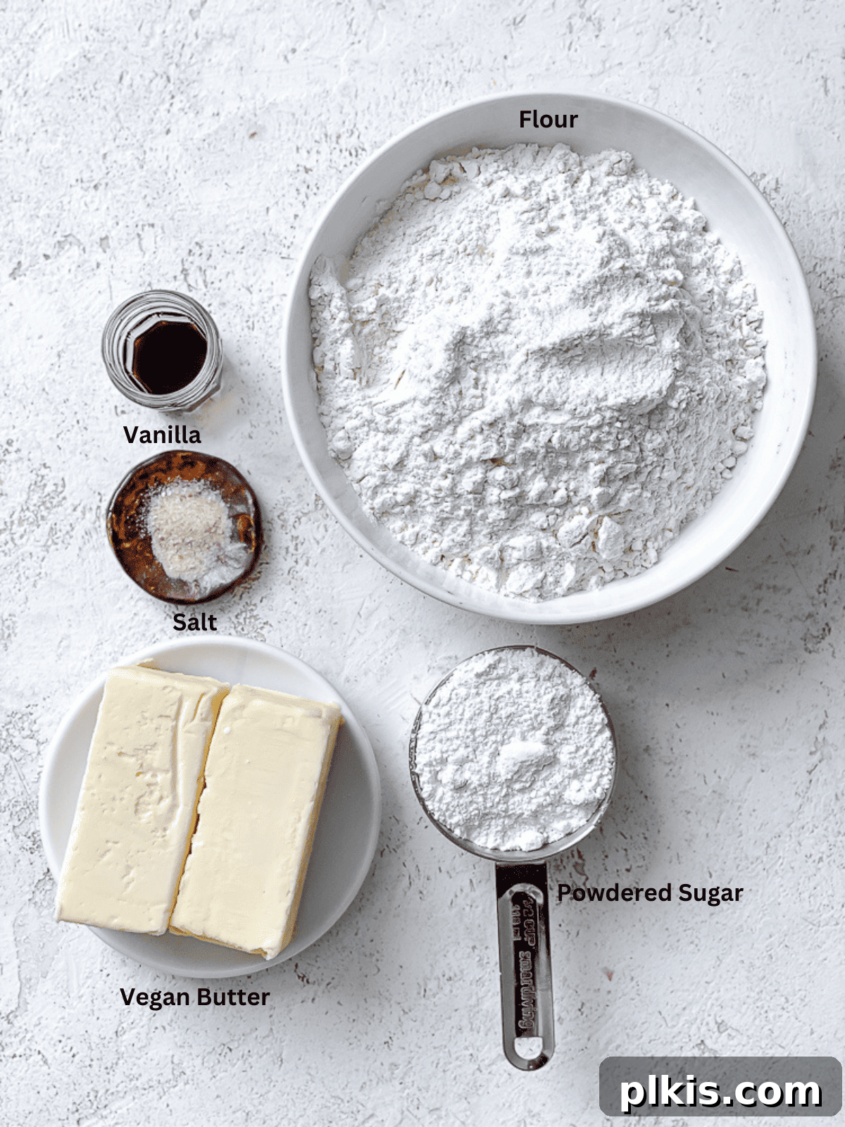 Flavorful Snowball Delights 3 All essential ingredients for Easy Snowball Cookies laid out on a clean white surface, showcasing the simplicity of the recipe