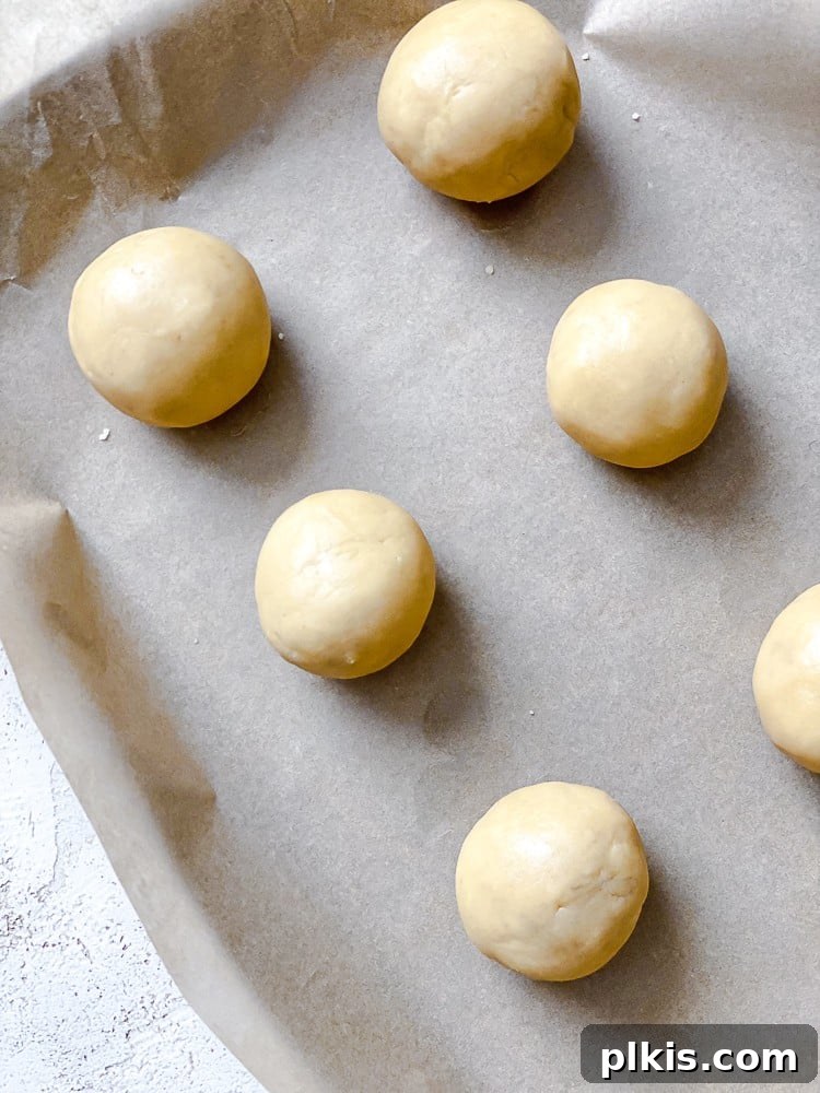 Flavorful Snowball Delights 6 Process shot showing small balls of vegan snowball cookie dough neatly arranged on a baking sheet, ready for the oven