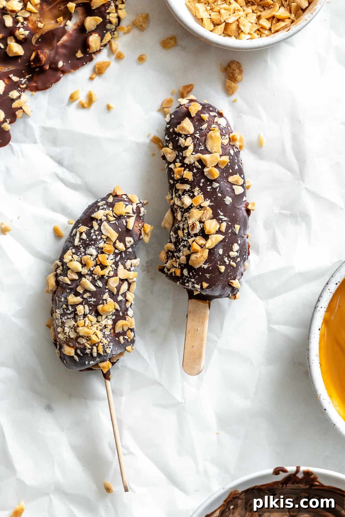 Peanut Butter Chocolate Banana Delights 2 Delicious completed Peanut Butter and Chocolate Covered Bananas on a pristine white surface, ready to be enjoyed as a healthy treat.