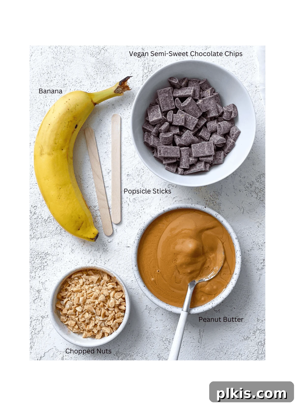 Peanut Butter Chocolate Banana Delights 3 Essential ingredients for Peanut Butter and Chocolate Covered Bananas displayed neatly on a white surface, including bananas, peanut butter, and chocolate chips.