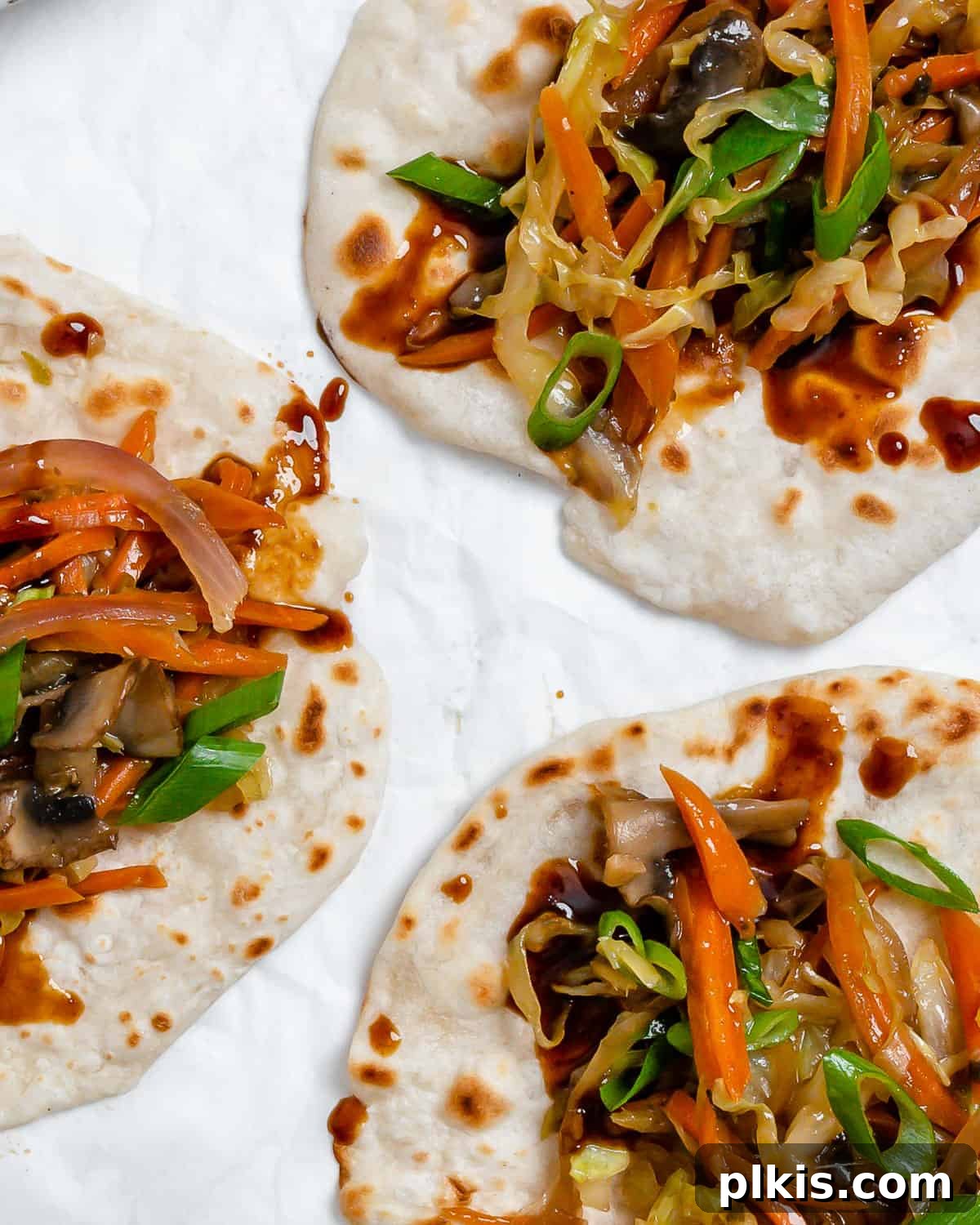 Vibrant Moo Shu Medley 2 Completed Moo Shu Vegetables on delicate mandarin pancakes, served against a pristine white backdrop, ready to be enjoyed.