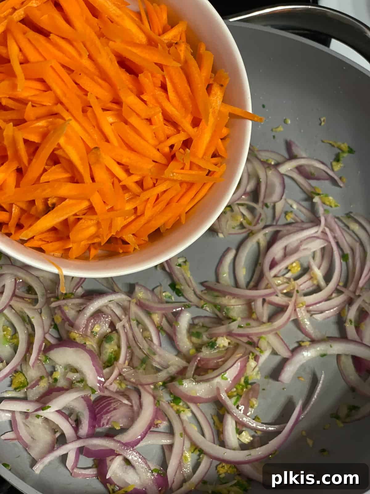 Vibrant Moo Shu Medley 7 A process shot showing matchstick carrots joining the onions and aromatics in the pan, adding color and texture to the Moo Shu Vegetable stir-fry.