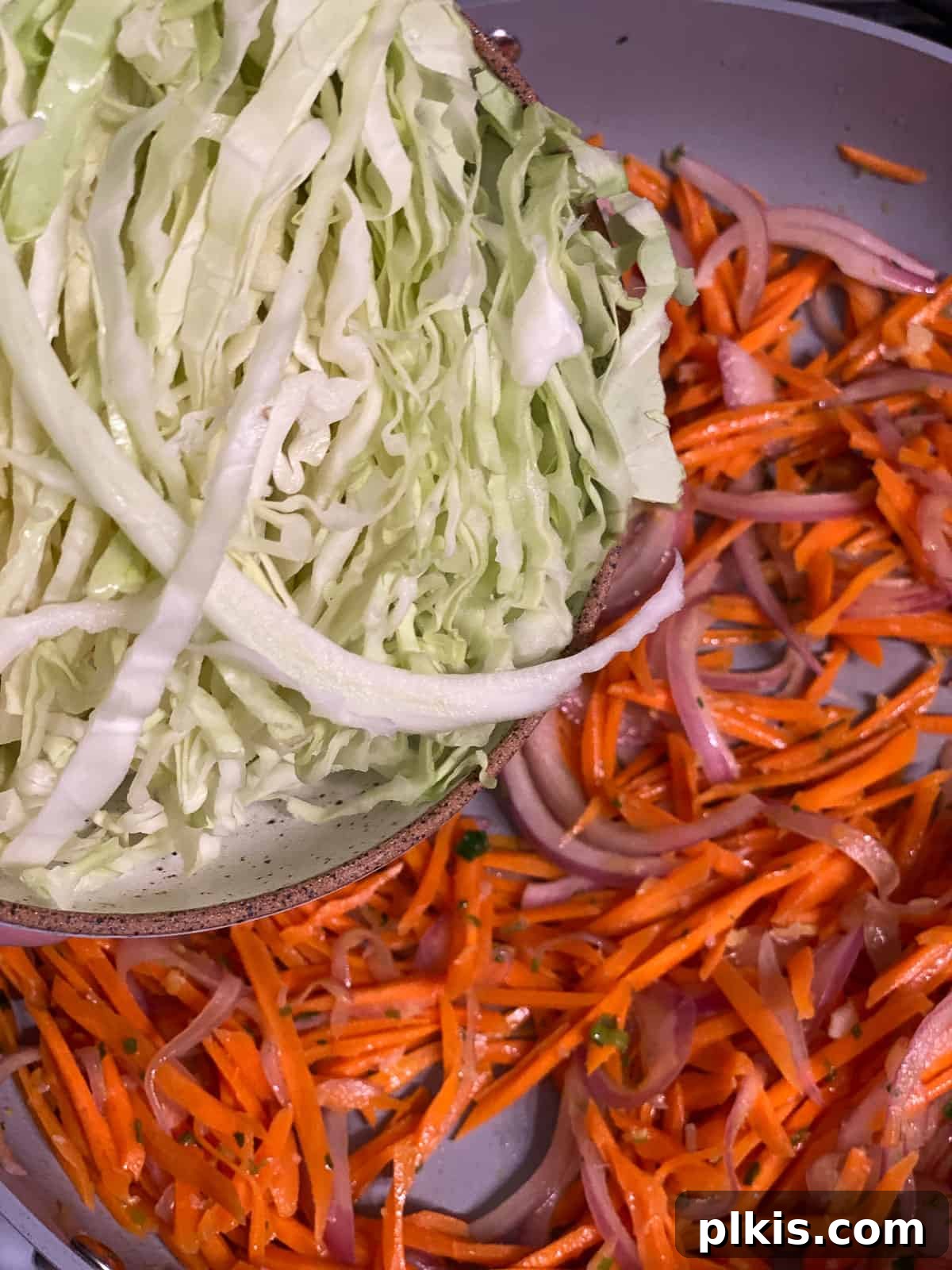 Vibrant Moo Shu Medley 8 A process shot of shredded cabbage being added to the stir-frying vegetables, indicating the next stage of the Moo Shu Vegetable recipe.