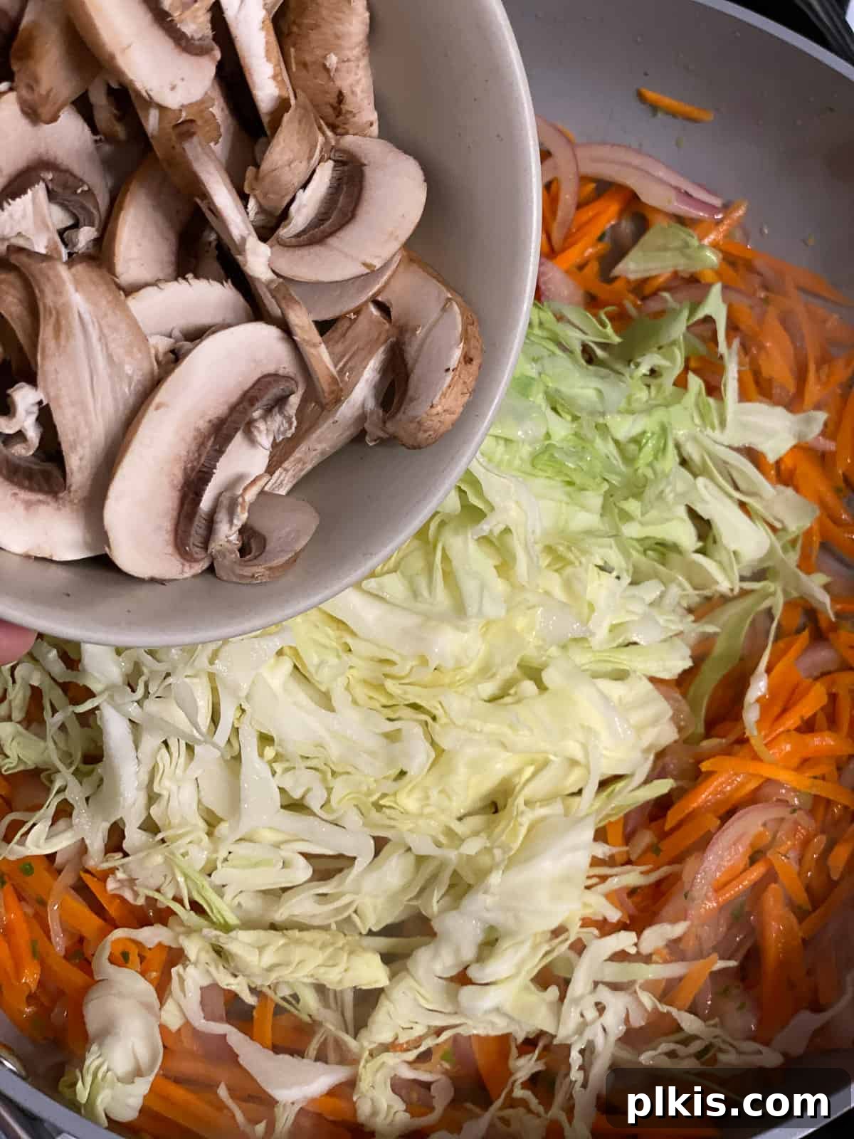 Vibrant Moo Shu Medley 9 A process shot capturing sliced mushrooms being added to the hot pan, joining the other vegetables for the Moo Shu Vegetable stir-fry.