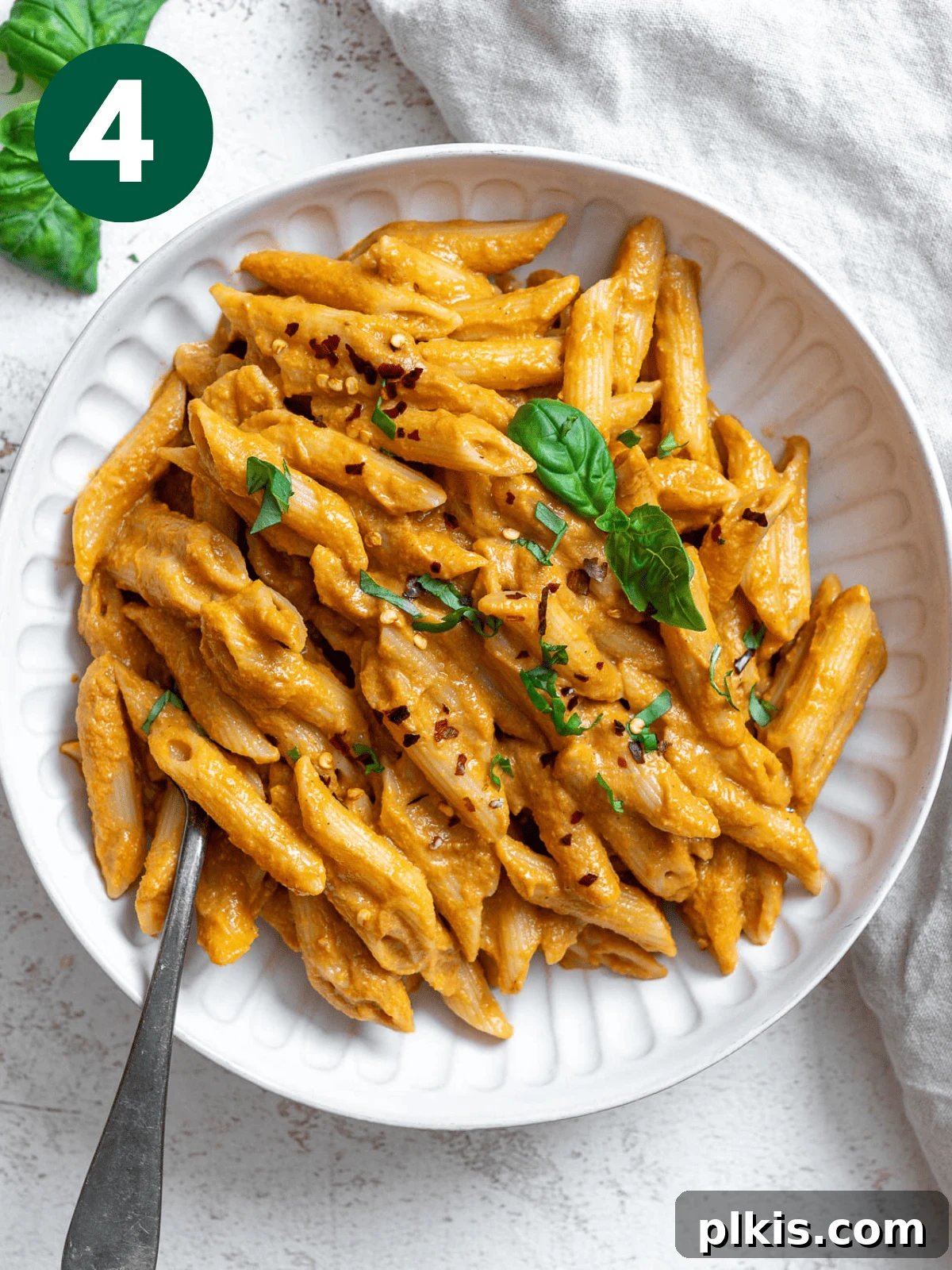Velvety Tomato Tofu Pasta Delight 7 Completed Creamy Tomato Tofu Pasta Sauce with pasta on a white surface