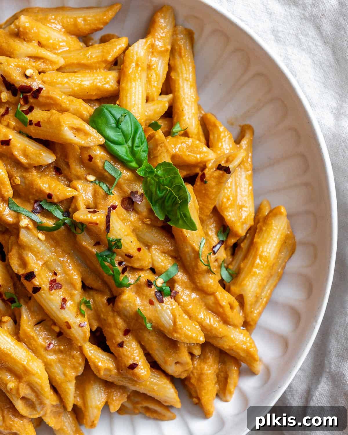 Velvety Tomato Tofu Pasta Delight 10 Completed Creamy Tomato Tofu Pasta Sauce with pasta on a white surface, close up