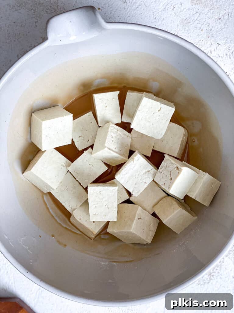 Golden Sesame Tofu 7 process shot of adding tofu to marinade in bowl